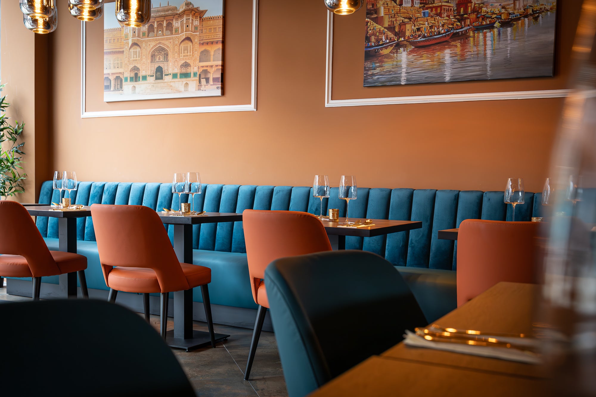 Blauwe velvet wandbank met oranje stoelen – Indian Fusion restaurant Almere