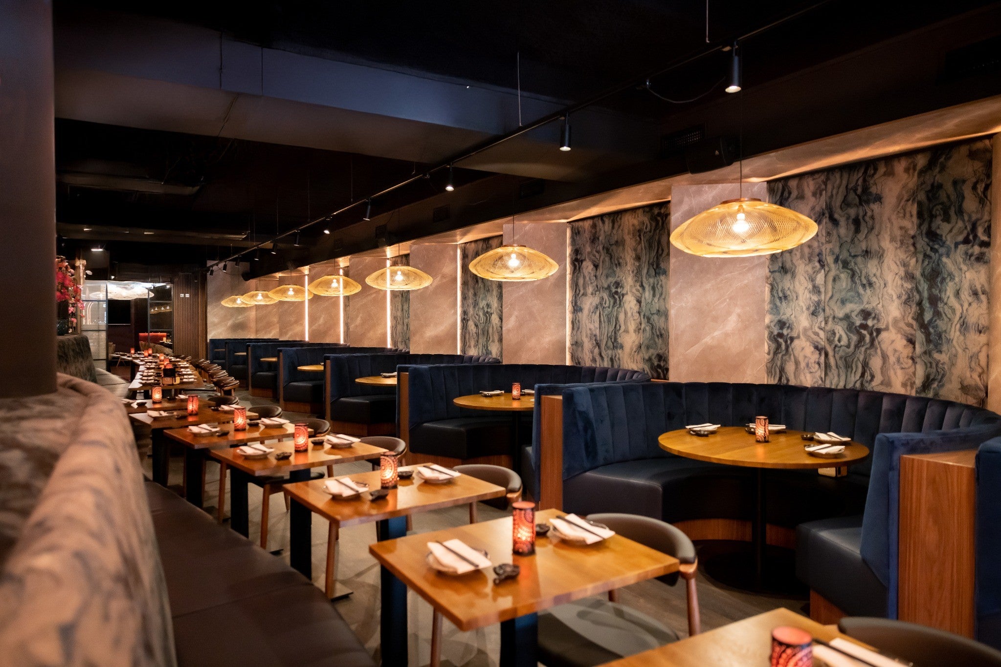 Luxe horeca-inrichting met op maat gemaakte ronde zitbanken en houten tafels in restaurant Blue Dragon Amsterdam, aan het Marie Heinekenplein.