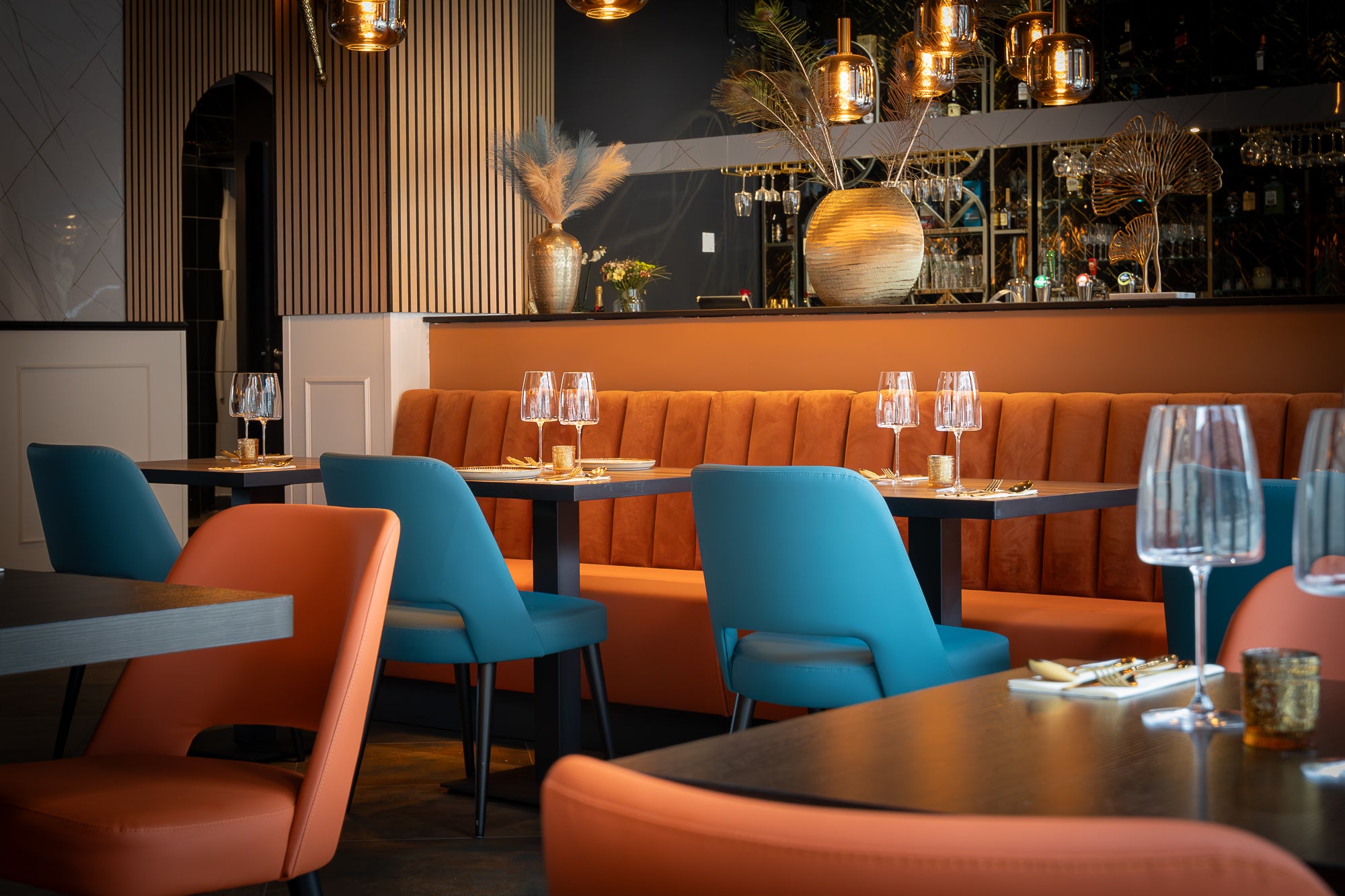 Oranje fluwelen horecabank op maat met blauwe stoelen – restaurantinrichting Indian Fusion Almere